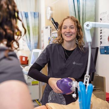 Respiratory care student holding equipment in a medical center