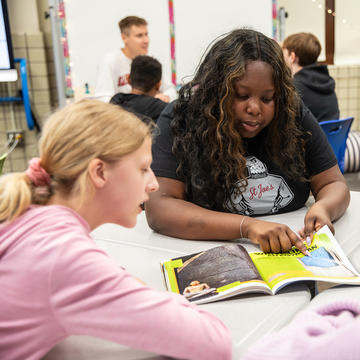 Female Saint Joseph's student teacher reading to elementary student