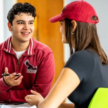 Young man speaking to woman at a table