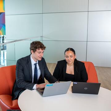 male and female students working on laptop together