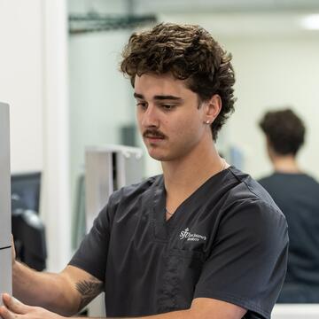 male nurse wearing dark gray scrubs