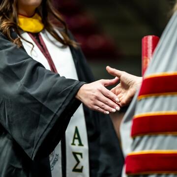 Dr. McConnell shaking hands with a graduate