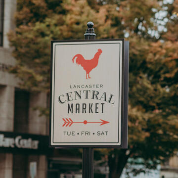 A sign with a rooster with the words central market