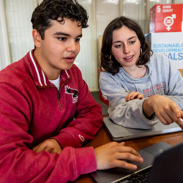 Students pointing to computer