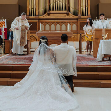 bride and groom kneeling at the altar