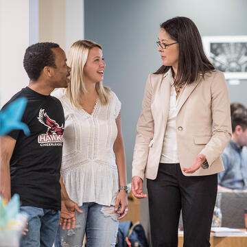 Students standing and talking with teacher