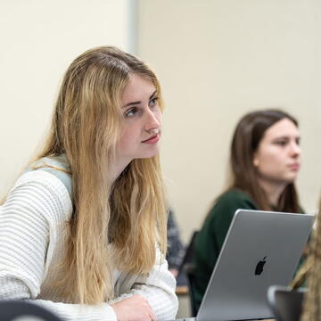 two female students in a classroom listening to a lecture