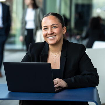 smiling sudent seated in front of laptop