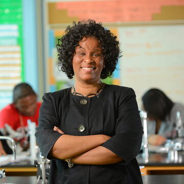 smiling educator standing in front of students