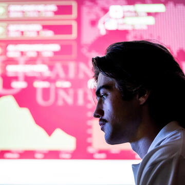 silhouette of male student against a pink background