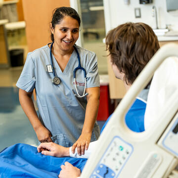 nurse comforting male patient who is lying in bed