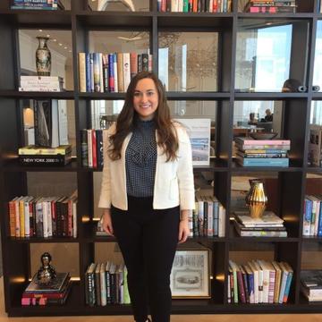 Kristin Thompson '18 standing in front of a bookshelf