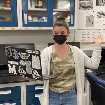 Student holds a laptop in Saint Joseph's biology lab.