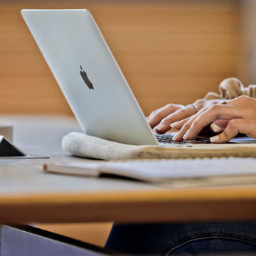 Student typing on laptop