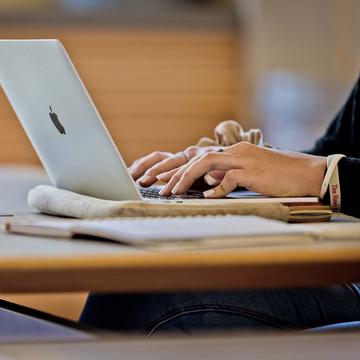 student typing on a laptop