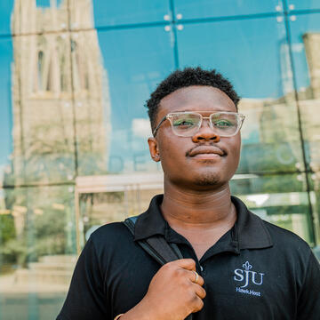 Student walking out side the library at Saint Joseph's University.