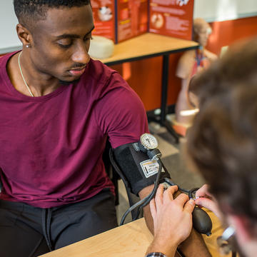 two saint joseph's university students practicing how to take blood pressure