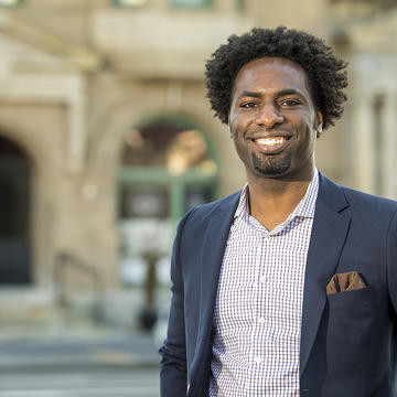 Jameel smiles with a blazer on 