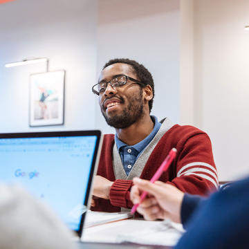 male student wearing glasses and red hoodie at saint joseph's university