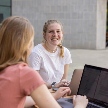 two saint joseph's university students talking outside on campus