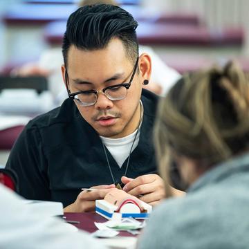 physician assistant student in a suturing lab