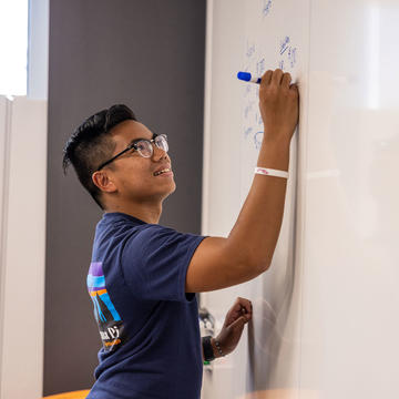 saint joseph's university student writing on a white board
