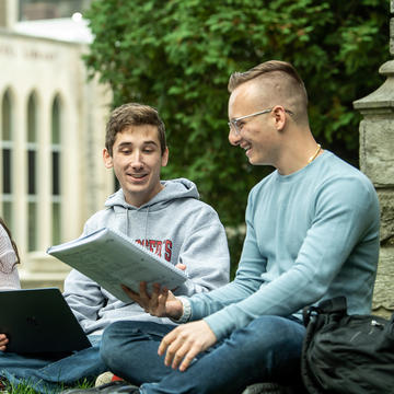 Two students sitting outside the Drexel Library at Saint Joseph's University