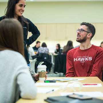 saint joseph's university students talking to each other in a classroom