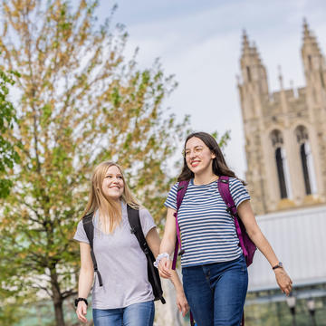 two saint joseph's university students walking outside with barbelin hall in the background