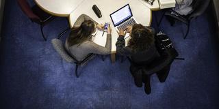 aerial shot of students around a quatrefoil shaped desk