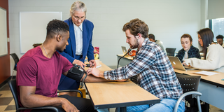Taking blood pressure in a health studies classroom