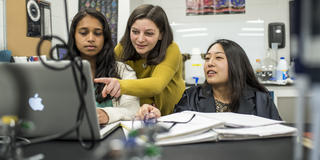 Faculty member at Saint Joseph's University teaching students in a lab in front of a monitor.