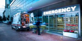 Entrance to an emergency room with an ambulance parked outside