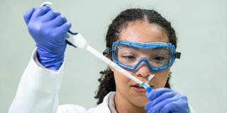 SJU pharmacy student using medical dropper in lab