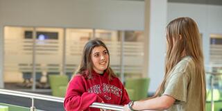 Two students conversing in a building at Saint Joseph's University's Lancaster location