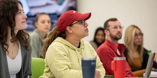 Students listening to a professor while sitting in class