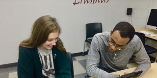 View of  tutor and student at a desk in the Writing Center reviewing the student's paper