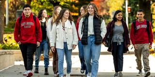 Group of male and female Saint Joseph's students walking together outside on campus