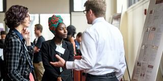 Two students hearing research presentation
