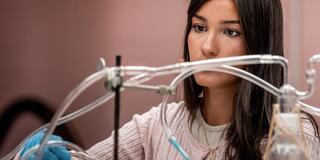McNulty Fellow_Mariana Rodriguez_In Lab Observing Liquid Running Through Tubing