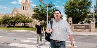 Two students crossing the road at a crosswalk.