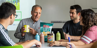 food marketing professor holding a can and pointing at a label