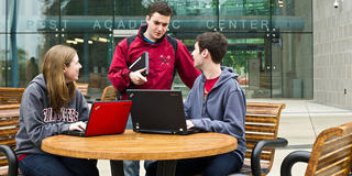 three saint joseph's university students outside of post academic center
