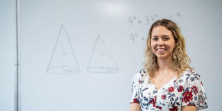 saint joseph's university female mathematics student standing in front of a white board