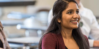 female college student with long hair inside a classroom