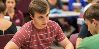 two male saint joseph's university students talking to each other