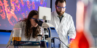 two pharmaceutical science students conducting research in a lab