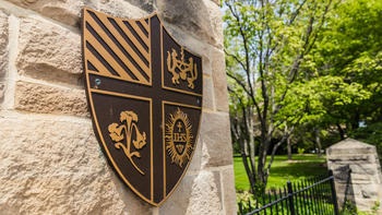 A closeup of the school crest embedded in stone.