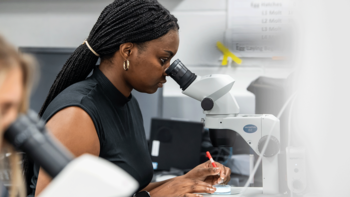female student looking through a microscope