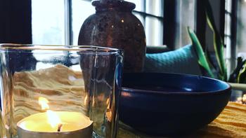 A candle and bowl on a wooden desk